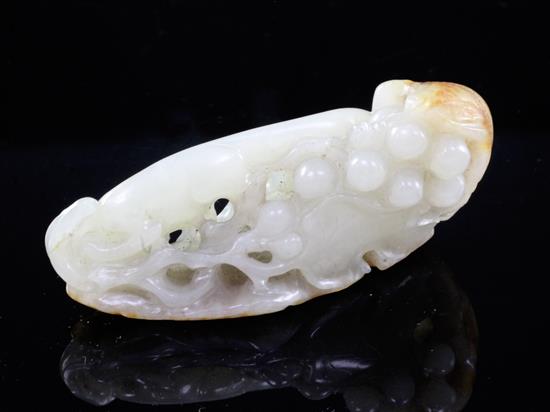 A Chinese celadon and russet jade squirrel and grape vine carving, 18th / 19th century, 6.8cm